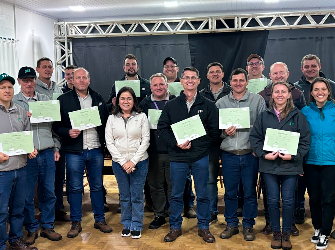 Imagem com 17 pessoas, sendo três mulheres e 14 homens, e algumas estão segurando um certificado em mãos.